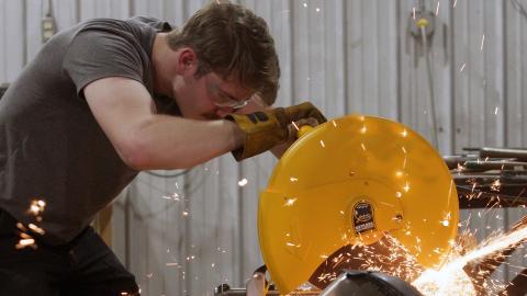 Sparks fly as a man uses a large circular saw