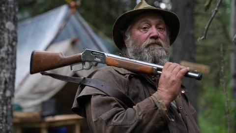Randy from the new season of Mountain Men with a rifle across his shoulder