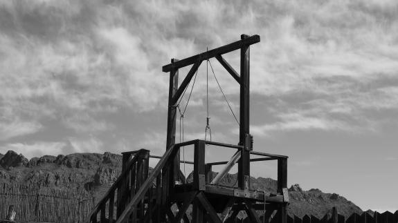 Black and white picture of a hangman’s gallows with a noose.