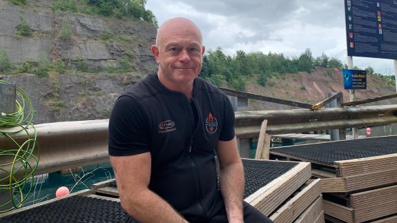 Ross Kemp sitting on a wooden crate