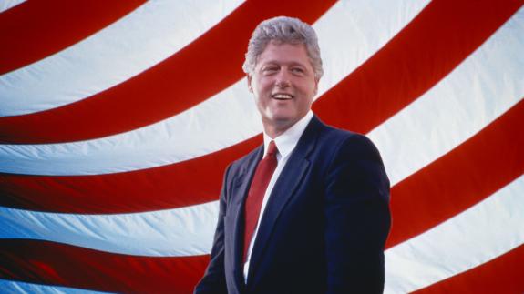 Bill Clinton in front of red and white stripes