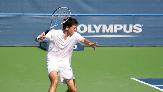 Tim Henman gears up to play a tennis shot