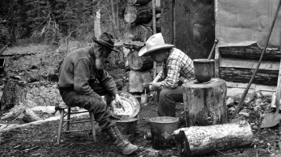 Gold rush miners with gold in a pan
