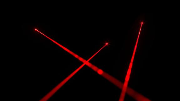 Red laser beams on black background