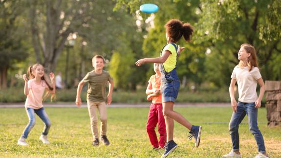 Cute little children playing with frisbee outdoors on sunny day
