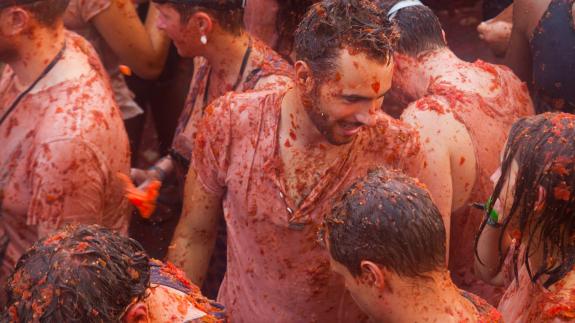  Battle of tomatoes. La Tomatina festival where people are fighting with tomatoes at street
