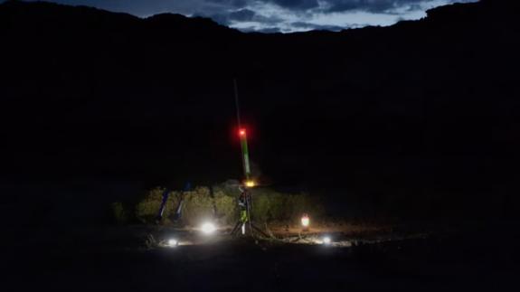 A small test rocket is about to be launched at night