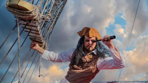 A pirate looks through a telescope on a ship