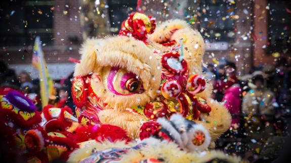 Confetti fills the air during a lion dance celebration during Chinese New Year