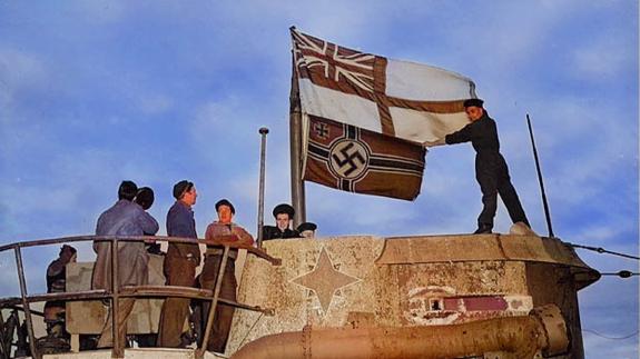 Seamen raise the White Ensign over a captured U-boat (colourised)