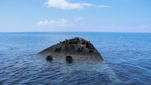 A tip of a bow's prow pointing out of the water