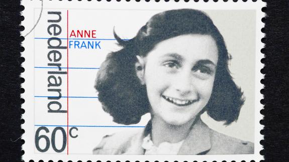 A photograph of a Dutch postage stamp showing an image of Anne Frank