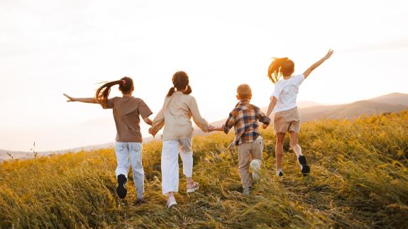 Children holding hands in a sunny meadow