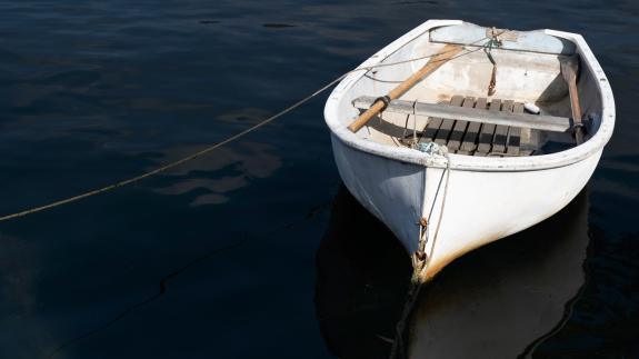 A photograph of a small boat in a dark sea