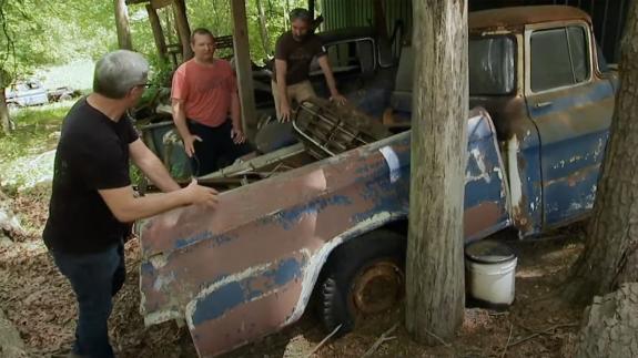 The pickers inspecting a rusty old truck