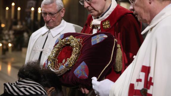 A woman prays in front of the Crown of Thorns held by Knights of the Holy Sepulchre