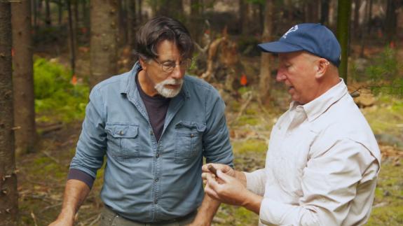 Gary Drayton holding up a find for Rick Lagina to look at