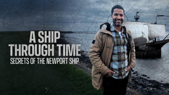 Sean Fletcher stands in front of the River Usk with a rendering of the Newport Ship sailing on it