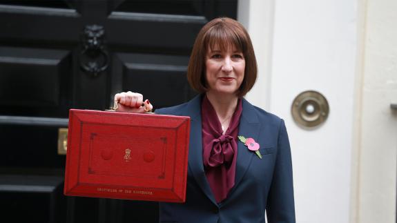 Rachel Reeves holding the red government dispatch box in front of 11 Downing Street in 2024