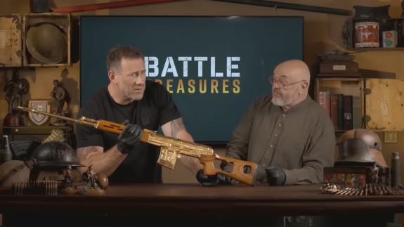 Jason Fox and Bruce Crompton inspecting a gold rifle on the set of 'Battle Treasures'