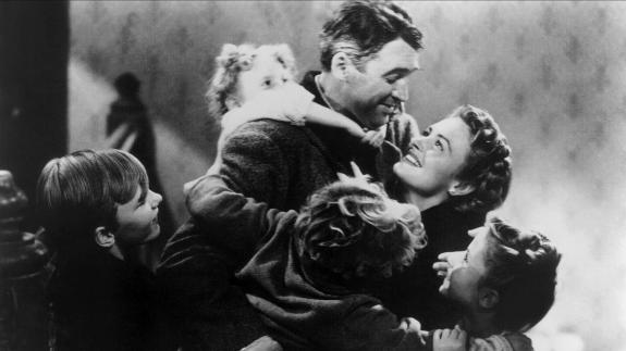 Actor James Stewart in 'It's A Wonderful Life' being hugged by his on-screen family