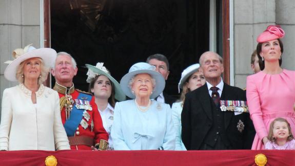 Members of the royal family, including Queen Elizabeth II, Prince Philip, King Charles III, Queen Camilla and Catherine, Princess of Wales stand of the balcony of Buckingham Palace and look at the sky