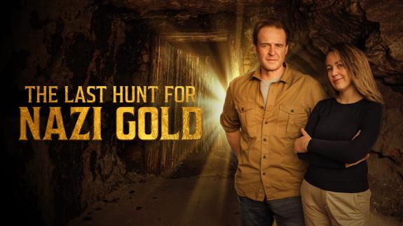 Guy Walters and Justine Ostrowska standing in a cave next to the show title