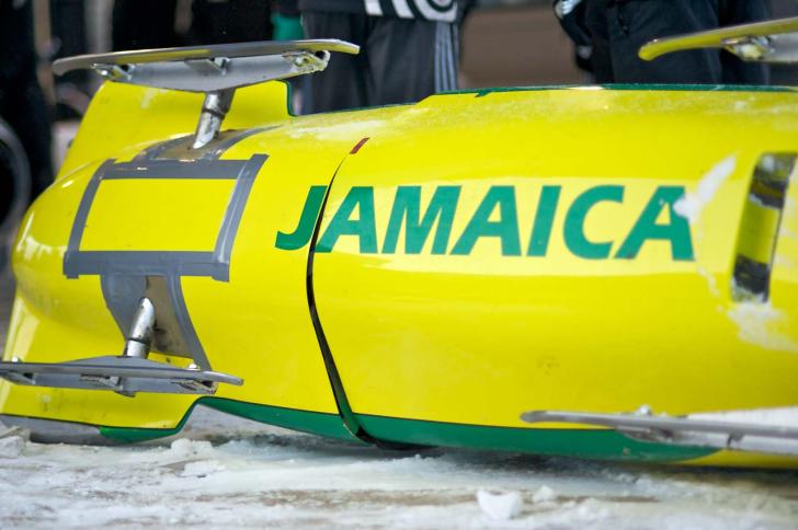A yellow bobsled with Jamaica written on it in green letters