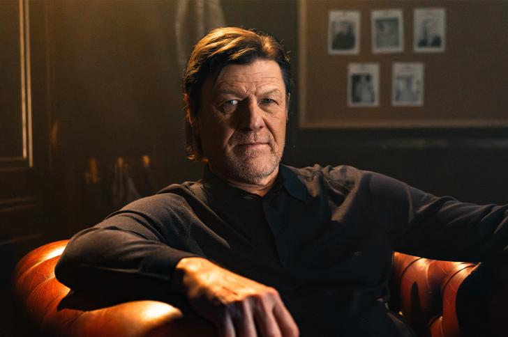 Sean Bean sitting in a large leather armchair