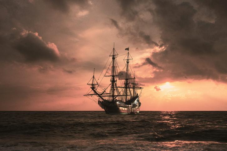A pirate ship on the sea at sunset