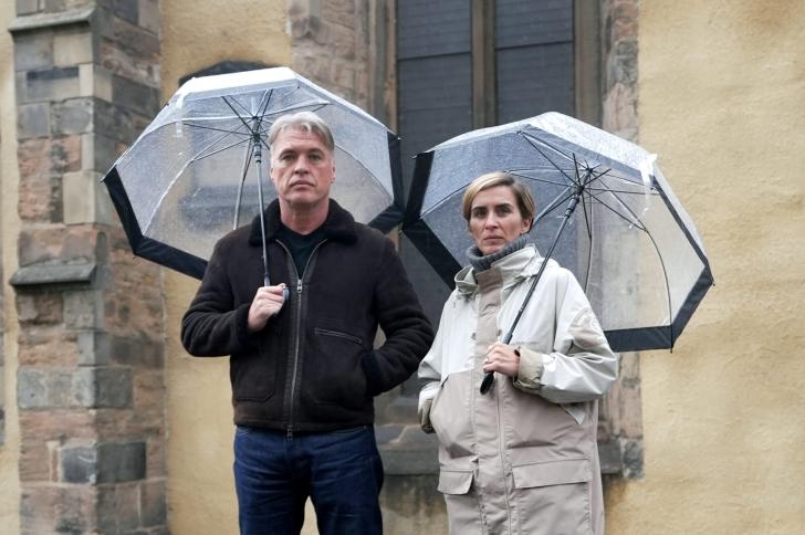 Vicky McClure and Jonny Owen standing together beneath umbrellas