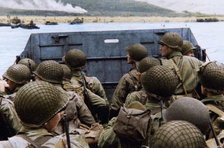 Soldiers aboard a landing craft approach the Normandy beaches during D-Day, depicted in a World War II documentary or drama.