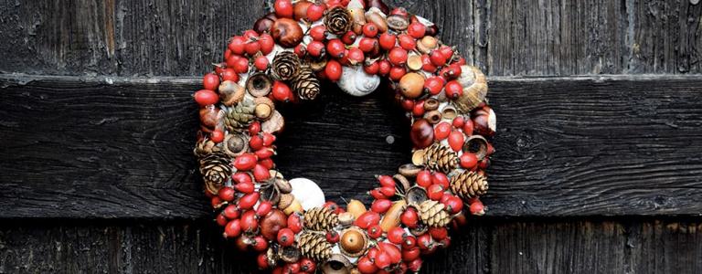 A red Christmas wreath on a wooden door