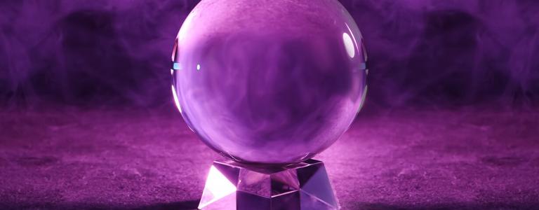 A photograph of a crystal ball surrounded by smoke and purple light