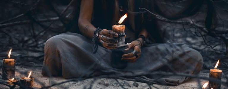 A witch holding candle close up