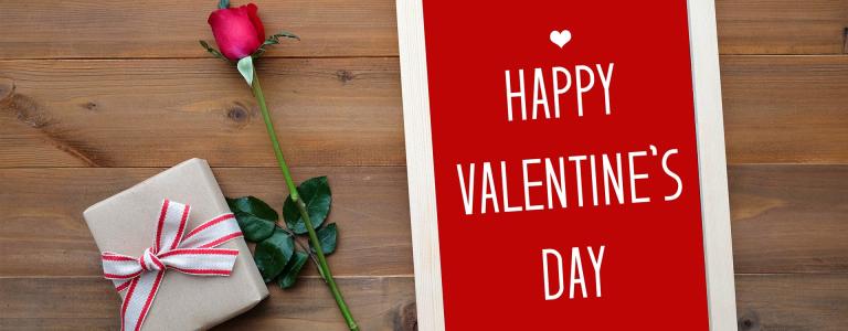 A sign next to a rose saying 'Happy Valentine's Day'