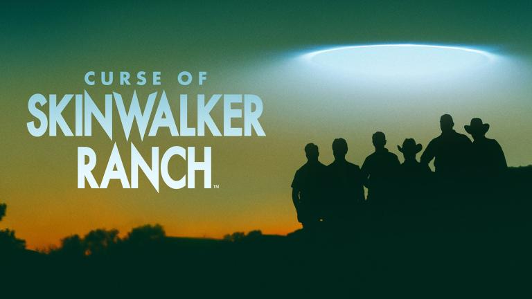 'CURSE OF SKINWALKER RANCH' - silhouettes of the Curse of Skinwalker cast standing against a green-orange sky with a mysterious flying saucer-shaped light above them