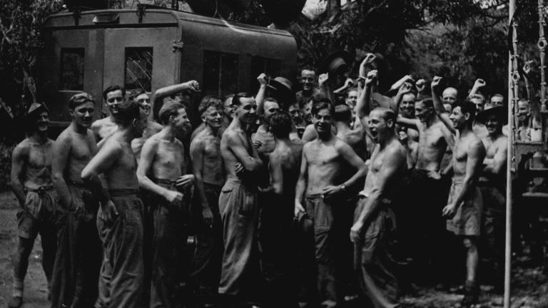 Black and white photograph of British troops in Burma celebrating after hearing the news of the Japanese surrender
