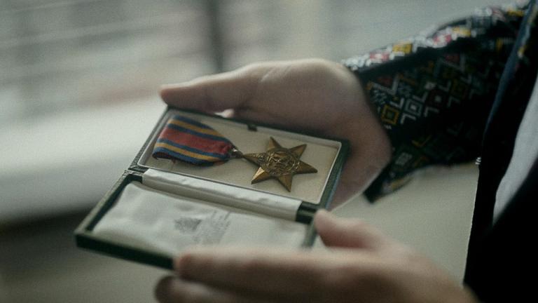 A man holding a Burma Star medal in a case