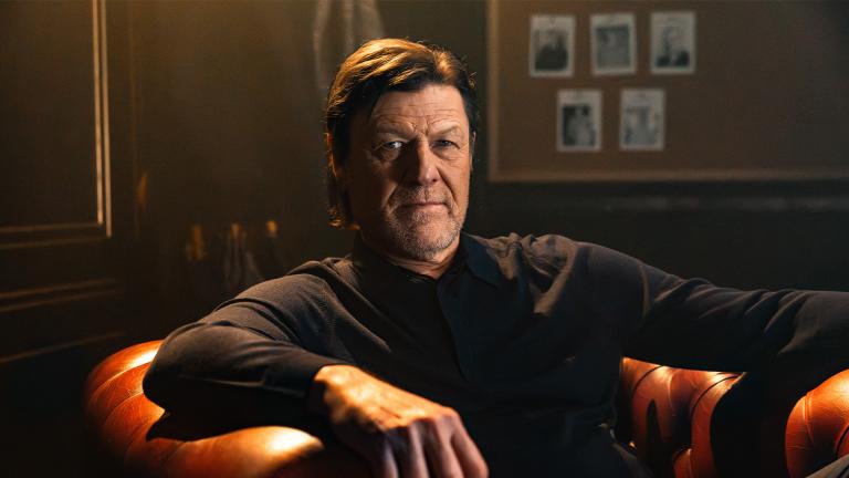 Sean Bean sitting in a large leather armchair